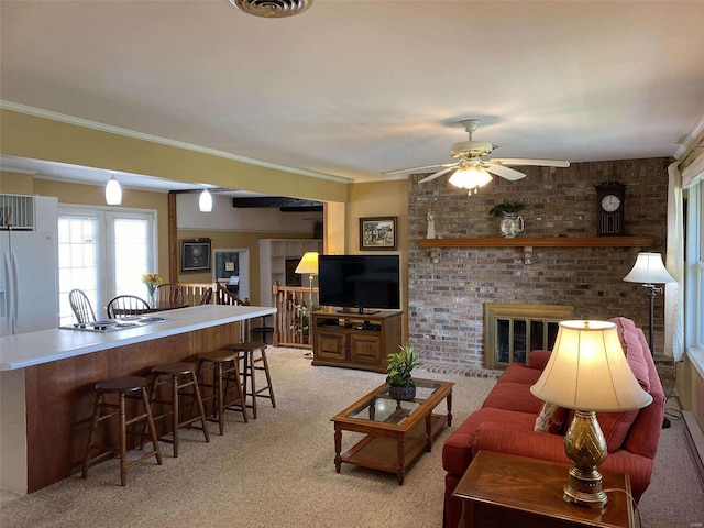 living room with ornamental molding, a brick fireplace, light colored carpet, bar area, and ceiling fan