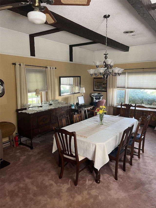 carpeted dining space with beam ceiling, a textured ceiling, a wealth of natural light, and ceiling fan with notable chandelier