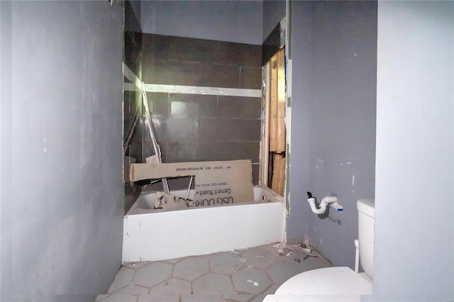 bathroom with tile patterned floors, a bathtub, and toilet