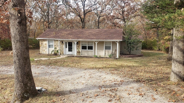 ranch-style house featuring covered porch and stone siding