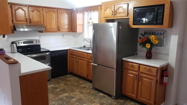 kitchen featuring brown cabinets, a sink, light countertops, under cabinet range hood, and black appliances
