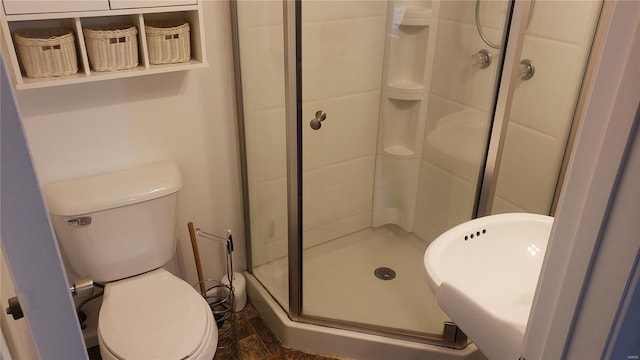 bathroom featuring a shower stall and toilet