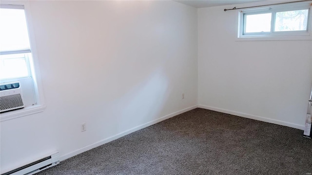 unfurnished room with a baseboard heating unit and dark colored carpet