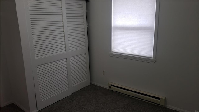 room details with carpet floors and a baseboard heating unit
