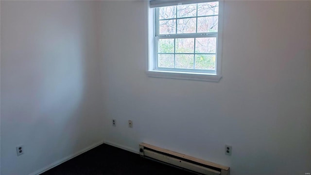 empty room with baseboards, a healthy amount of sunlight, and a baseboard radiator