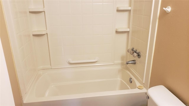 bathroom featuring toilet and tiled shower / bath