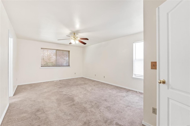 carpeted spare room with ceiling fan