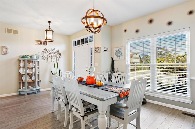 dining room featuring wood-type flooring and an inviting chandelier