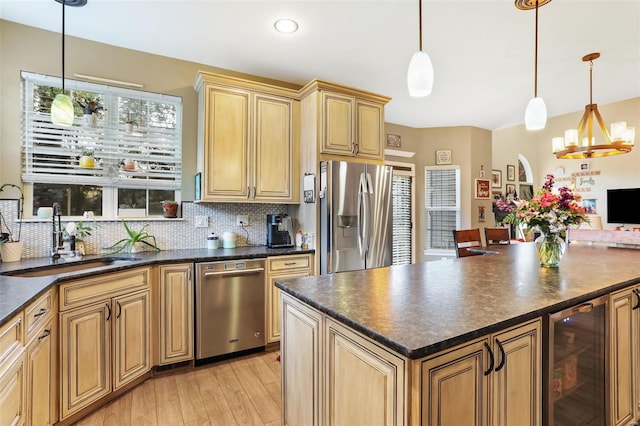 kitchen with wine cooler, tasteful backsplash, hanging light fixtures, appliances with stainless steel finishes, and sink