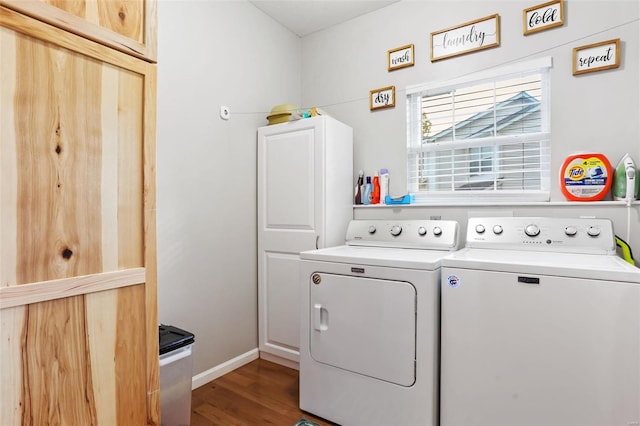 laundry area with washing machine and clothes dryer, wood-type flooring, and cabinets