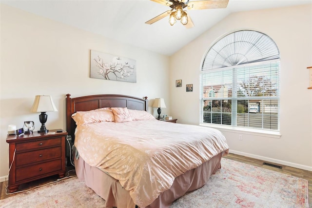 bedroom featuring light hardwood / wood-style floors, ceiling fan, and vaulted ceiling