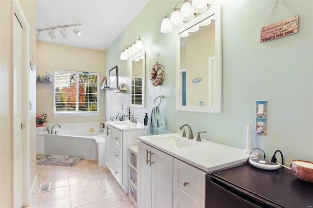 bathroom featuring vanity, track lighting, a bathtub, and tile patterned floors