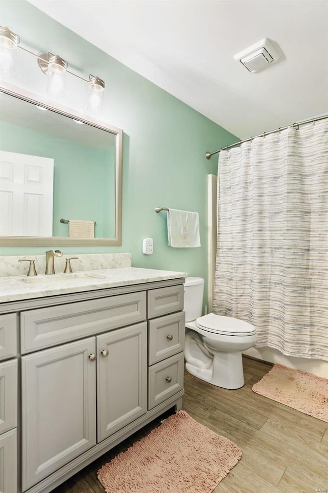 bathroom with vanity, a shower with shower curtain, wood-type flooring, and toilet