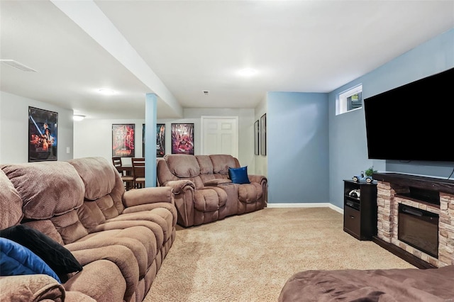 carpeted living room featuring a stone fireplace