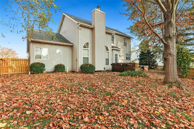 rear view of property with a hot tub