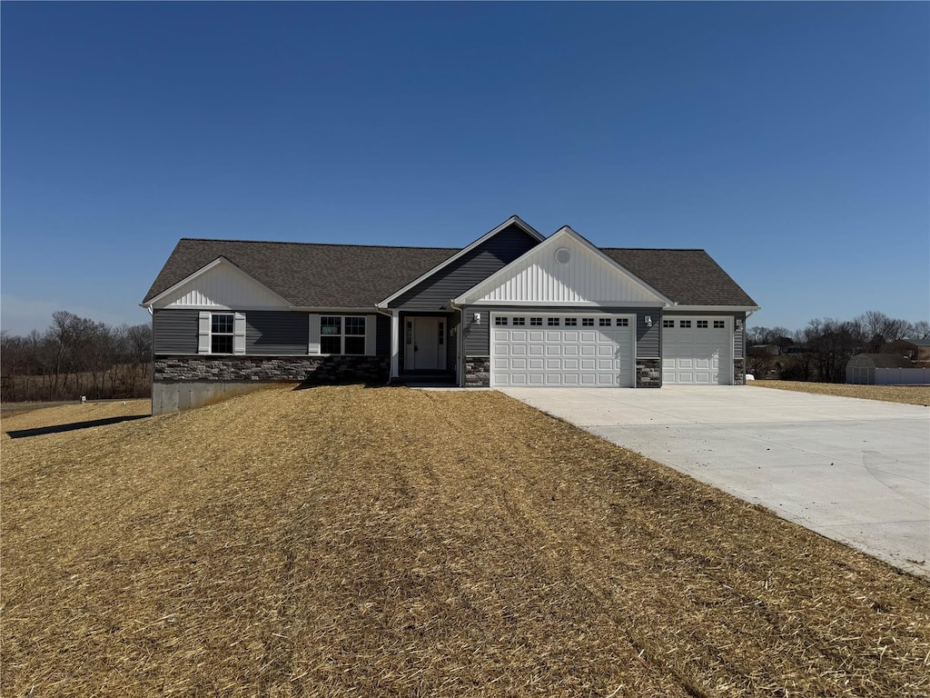 view of front of house with stone siding, driveway, and a garage