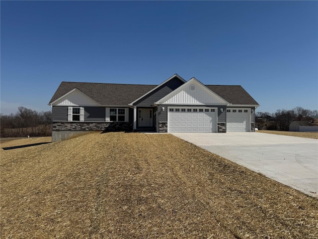 view of front of house with stone siding, driveway, and a garage