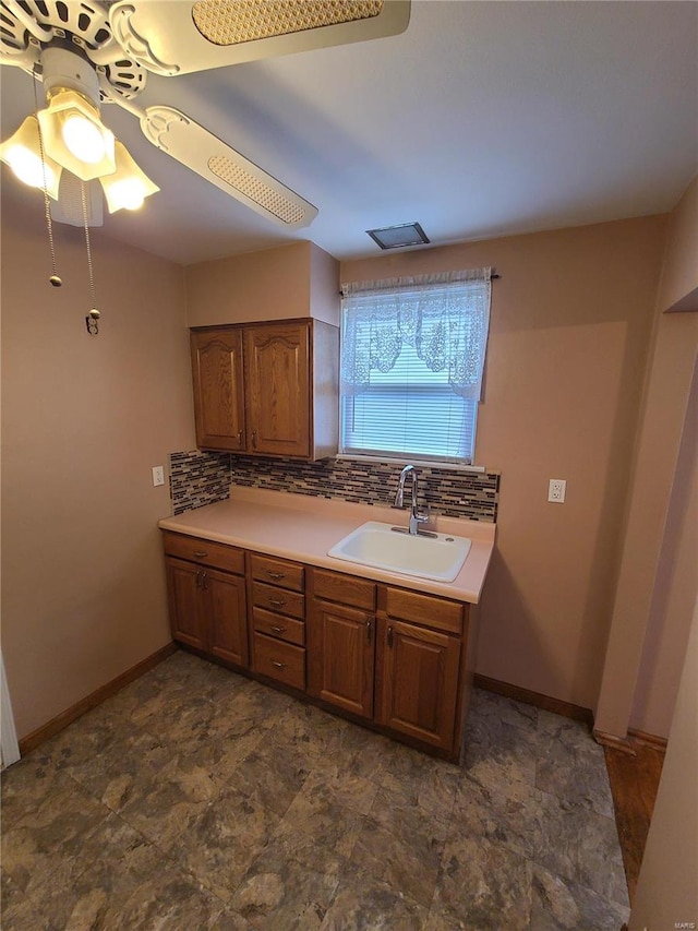 kitchen featuring tasteful backsplash, ceiling fan, and sink