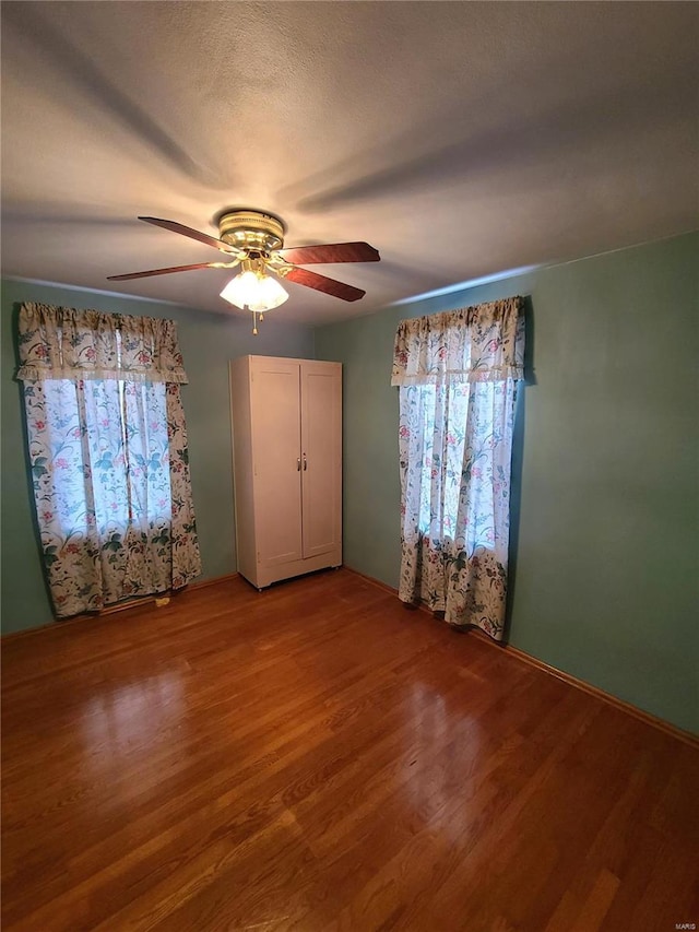 unfurnished bedroom with ceiling fan, hardwood / wood-style floors, and a textured ceiling