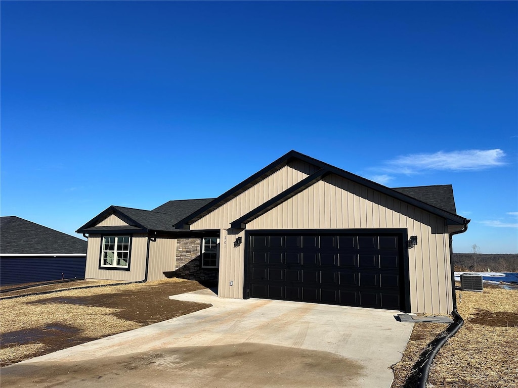 modern farmhouse style home featuring central AC unit and a garage