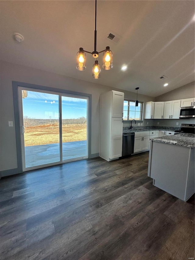 kitchen featuring electric stove, stainless steel microwave, decorative light fixtures, and white cabinets