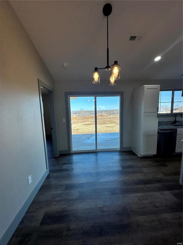 unfurnished dining area featuring baseboards, visible vents, dark wood-type flooring, vaulted ceiling, and a notable chandelier