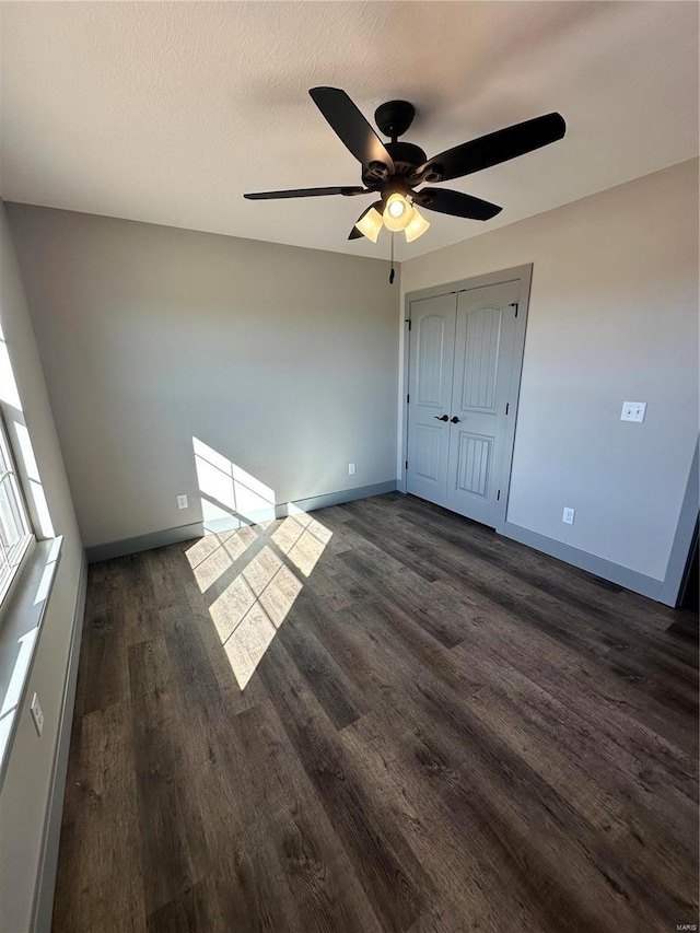 unfurnished room featuring dark wood-style floors, ceiling fan, a textured ceiling, and baseboards