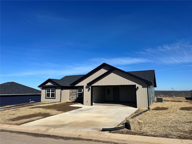 modern farmhouse style home featuring driveway, an attached garage, and central air condition unit