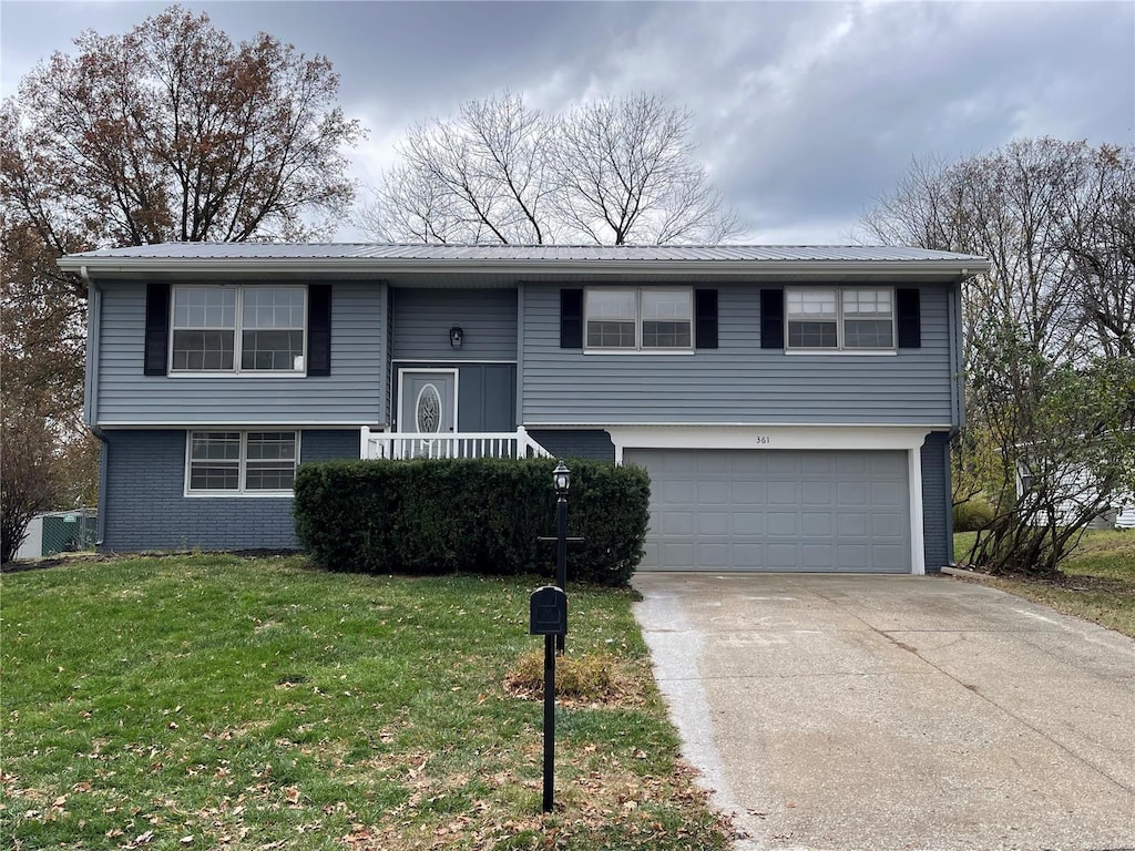 bi-level home featuring a garage and a front lawn