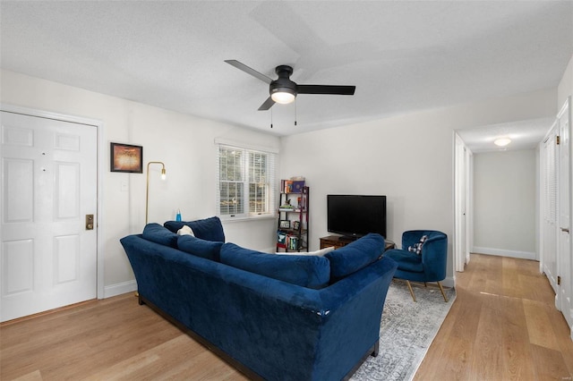 living room featuring light hardwood / wood-style floors and ceiling fan