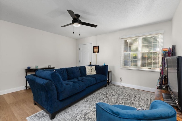 living room with ceiling fan, a textured ceiling, and hardwood / wood-style floors