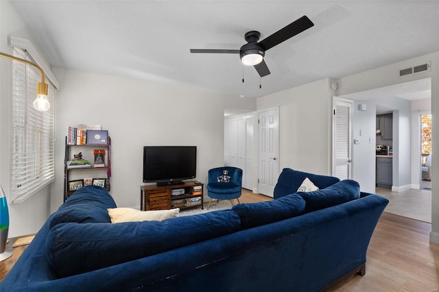 living room featuring light wood-type flooring and ceiling fan