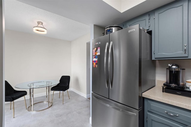 kitchen featuring a textured ceiling and stainless steel refrigerator