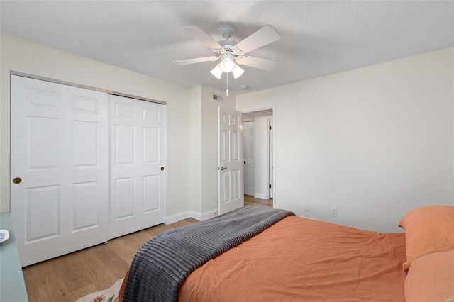 bedroom with light hardwood / wood-style floors, a closet, and ceiling fan