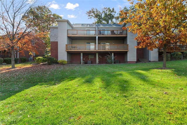 rear view of house with a wooden deck and a yard