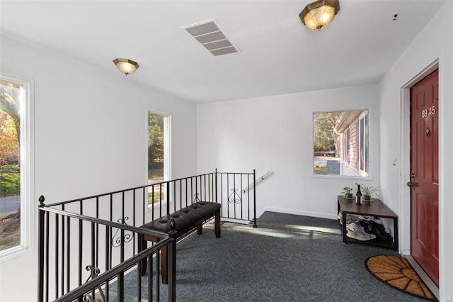 corridor featuring a wealth of natural light and carpet