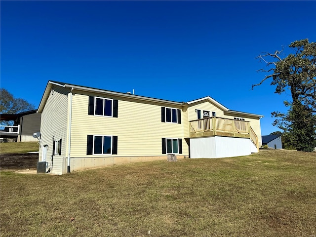 back of property with a yard, a deck, and central AC unit