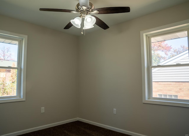 carpeted spare room featuring plenty of natural light and ceiling fan