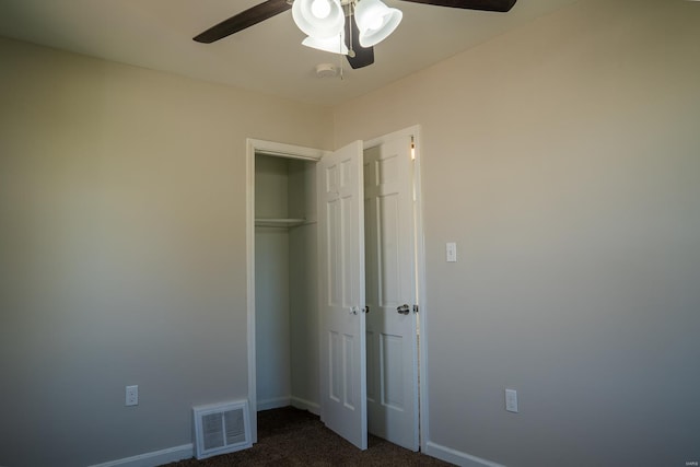 unfurnished bedroom with a closet, ceiling fan, and dark colored carpet