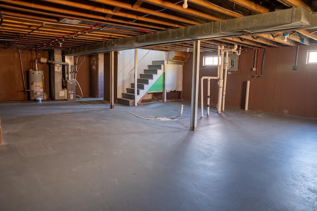 basement with heating unit, plenty of natural light, and gas water heater