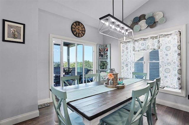 dining room featuring an inviting chandelier, vaulted ceiling, and dark hardwood / wood-style flooring