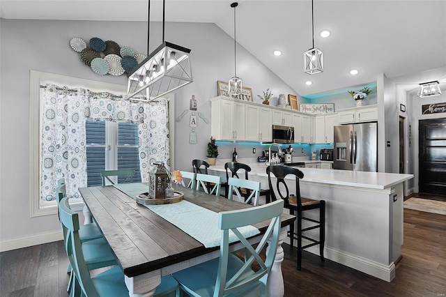 kitchen featuring dark hardwood / wood-style flooring, white cabinets, stainless steel appliances, and pendant lighting