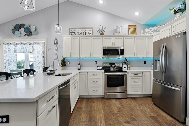 kitchen with sink, kitchen peninsula, stainless steel appliances, pendant lighting, and dark hardwood / wood-style floors