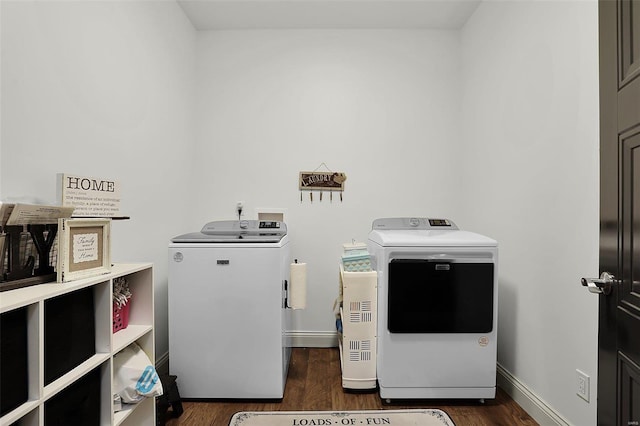 laundry room with washer and dryer and dark wood-type flooring