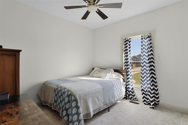 carpeted bedroom featuring multiple windows and ceiling fan