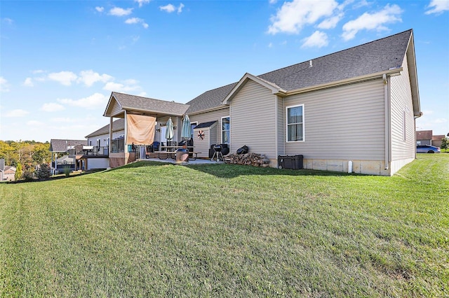 rear view of property featuring a patio and a lawn