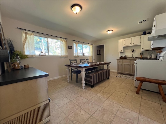 dining space featuring sink and light tile patterned floors