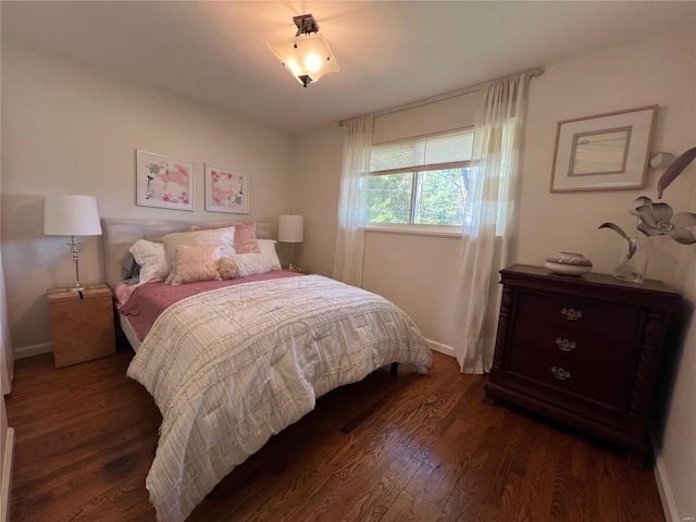 bedroom with dark wood-type flooring