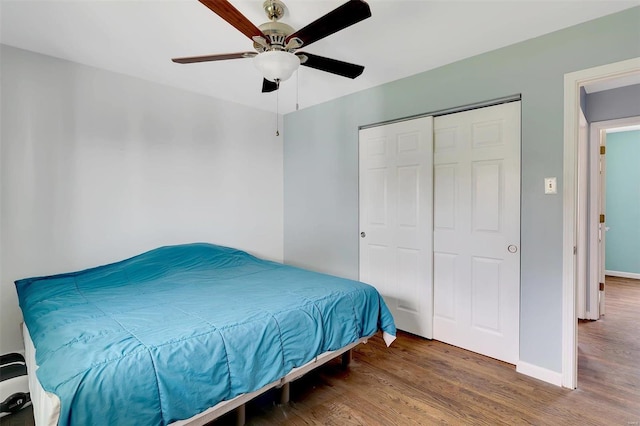 bedroom with ceiling fan, a closet, and wood-type flooring