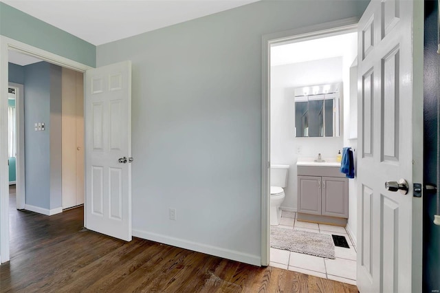 bathroom with wood-type flooring, vanity, and toilet